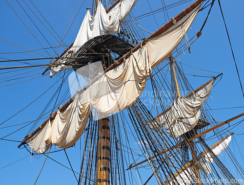 Image of Sailing, boat and mast outdoor with rope for travel, journey and adventure by blue sky in summer in the morning. Ship, wood pole and vintage schooner vessel on a cruise, rigging and transportation