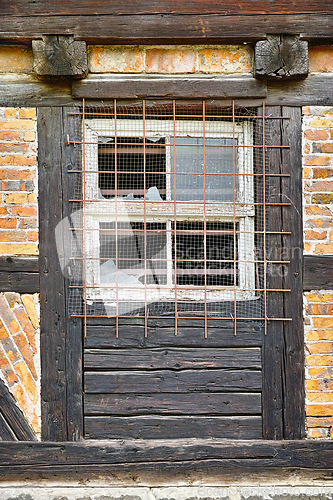 Image of Old, broken window and exterior with cage or brick wall of abandoned house, building or wooden frame. Historic outdoor bunker of rubble, glass crack or damage from war wreck, destruction or vandalism