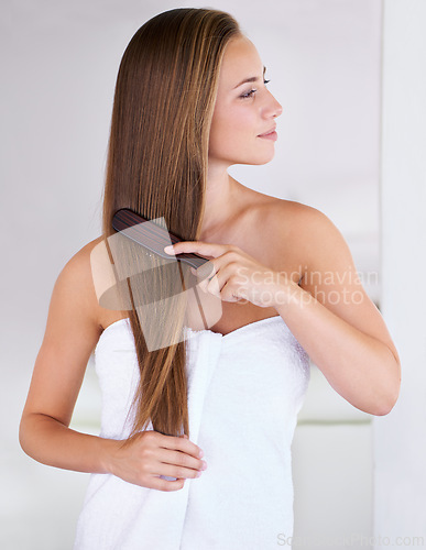 Image of Beauty, brush and hair care of woman in bathroom in home for cosmetics, cleaning or wellness for healthy growth. Hairstyle, towel or combing for morning routine, keratin treatment and person grooming