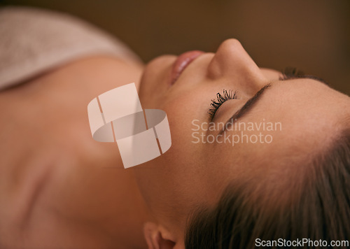 Image of Woman, lying and relax in spa for luxury or peace, massage therapy or skincare and calm to free tension. Female person, closeup and wellness for stress relief or rest for wellbeing with aromatherapy.