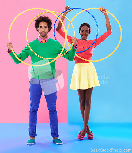 Image of People, smile or hoop for fashion, casual or spring outfit for playful aesthetic on color block background. Portrait, man or woman for plastic toy in funky, colorful or stylish clothing in studio