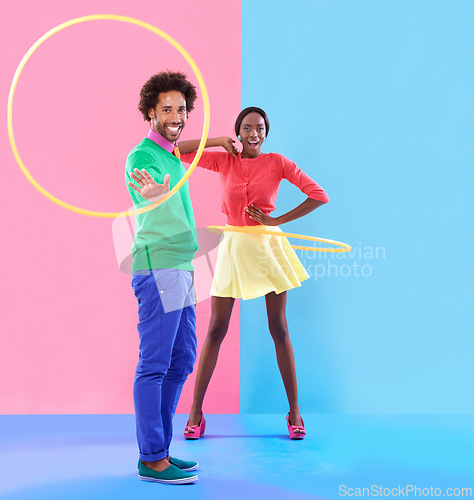 Image of Couple, fashion and trendy in studio with colour clothes, smile and playful expression on black people together. Artistic, aesthetic in retro style for unique designer, summer fun and hula hoop