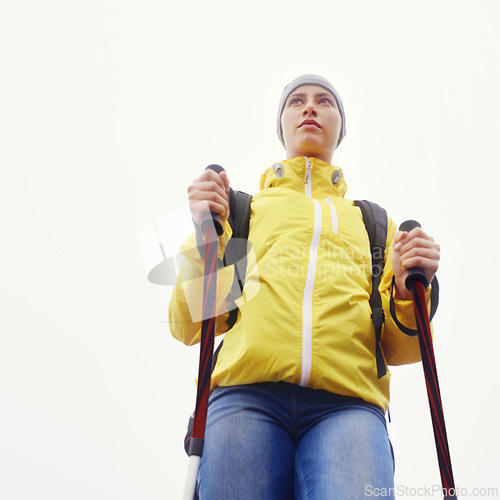 Image of Woman, hiking and outdoor fitness in nature with gear for travel, adventure and sightseeing in white background. Explore, low angle and person in trekking pole for wellness, health or balance.