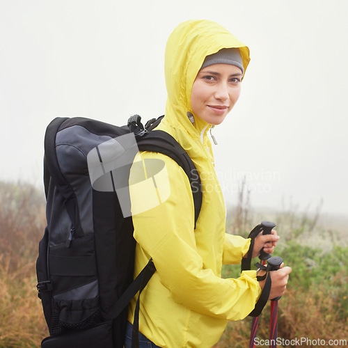 Image of Portrait, female hiker and fog on mountain trail, exercise and cardio for fitness in nature. Smile, walking stick and gear for training and morning overcast weather, workout and happy or rest on path