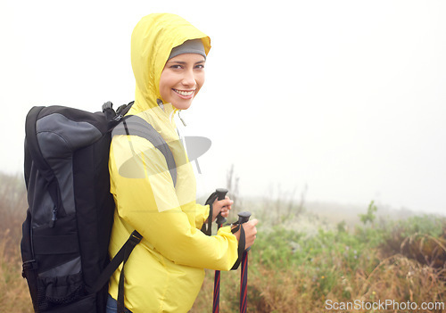 Image of Portrait, woman hiker and smile on mountain trail, exercise and cardio for fitness in nature. Fog, walking stick and gear for training and morning overcast weather, workout and happy or rest on path