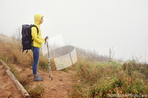 Image of Hiking woman, fog and exercise for cardio, walking stick and activewear for fitness. Backpack, adventure or mountain trail with morning overcast, sport or female athlete in nature and resting