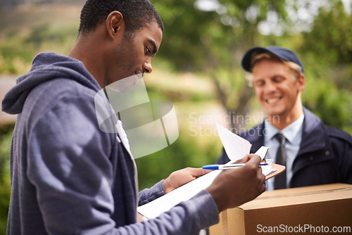 Image of Courier, men and client signing for a delivery, clipboard and product with industry and box. People, service and employee with a customer and document with shipping and post with paperwork and stock