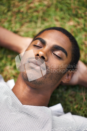 Image of Black man, relax and laying on grass, nature and summer in garden for vacation mindfulness or stress free. Enjoy, dreaming of future holiday plans, sunshine after work week, calm and rest for freedom