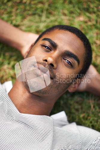 Image of Black man, relax and lying on grass while resting, sleeping and enjoy summer or nature outdoor. Male person, smile and sunshine after holiday, calm guy and happiness in garden or field or outside