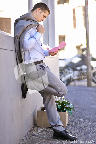 Image of Businessman, city and unemployment with job loss or stress and thinking of career crisis. Salesman, pink slip and mental health or anxiety in street, reading and fired or termination of work contract