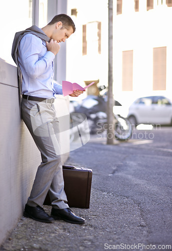 Image of Business, job loss and man on street, fired and reading letter of unemployment on city sidewalk. Anxiety, mental health and sad businessman on road with termination notice, briefcase and pink slip