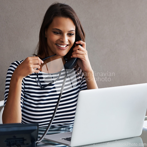 Image of Telephone, smile and business woman with laptop in conversation, talk or listening to contact with glasses in startup office. Landline, computer or secretary on call, receptionist or creative at desk