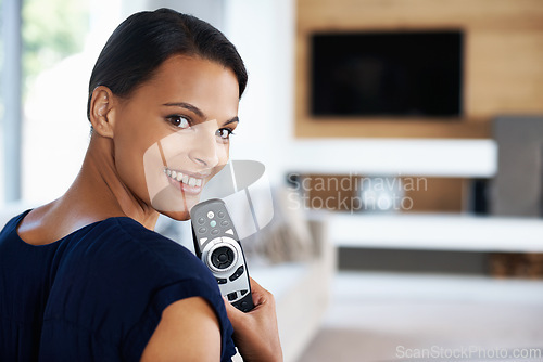 Image of Portrait, smile and woman watching tv in living room of home to relax with subscription streaming service. Face, sofa for tv and happy young person with remote for channel surfing in apartment