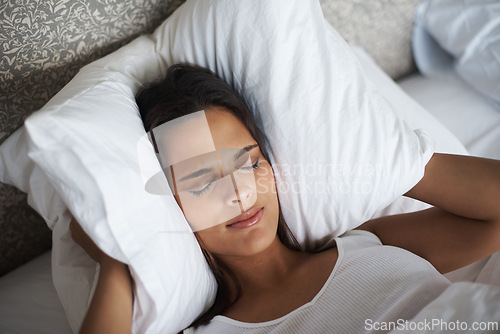 Image of Woman, pillow and frown for noise, stress or tired for insomnia or nightmare in bedroom in Las Vegas. Mental health, female person and angry for sleepless, fatigue and loud sound in hotel room