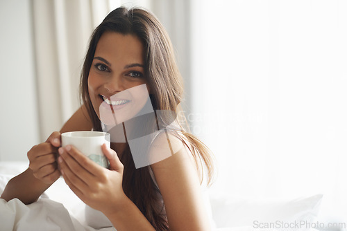 Image of Smile, portrait and woman with coffee in bedroom with caffeine to wake up in morning at home. Happy, relax and comfy young female person drinking mug of cappuccino, espresso or latte in apartment.