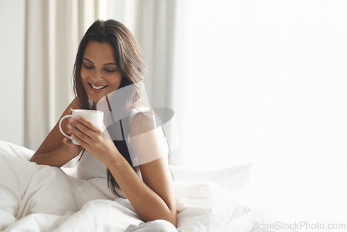 Image of Happy, calm and woman with coffee in bedroom with caffeine to wake up in morning at home. Smile, relax and comfy young female person drinking mug of cappuccino, espresso or latte in apartment.