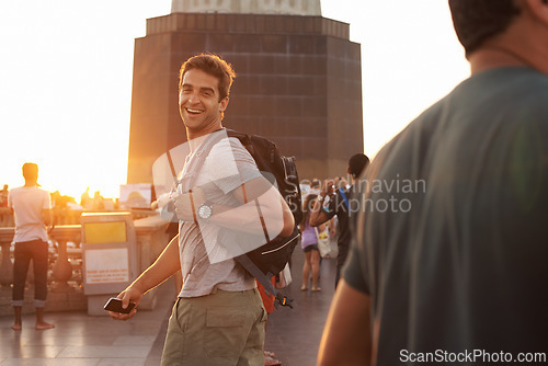 Image of Portrait, smile and man with backpack sunset, tourist and travel abroad for adventure or vacation. Happy person, laughing and holiday journey in city with casual outfit, smartphone and joyful face