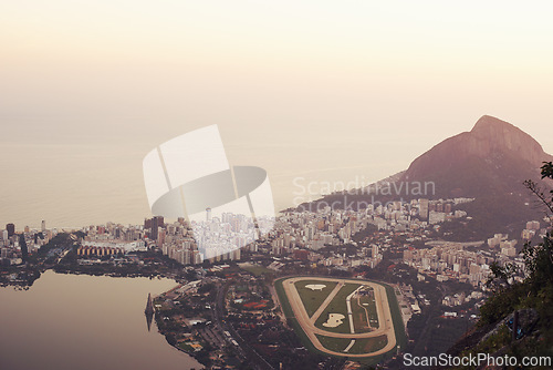 Image of Mountain, city and landscape at sunset with ocean or stadium from drone in urban Cape Town. Cityscape, aerial view and calm skyline with hill on holiday or travel on vacation with sea on horizon