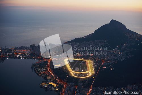 Image of Mountain, city and lights at night with ocean or highway in urban landscape of Cape Town. Cityscape, drone or aerial view of hill on holiday or travel on vacation with sunset on sea or horizon