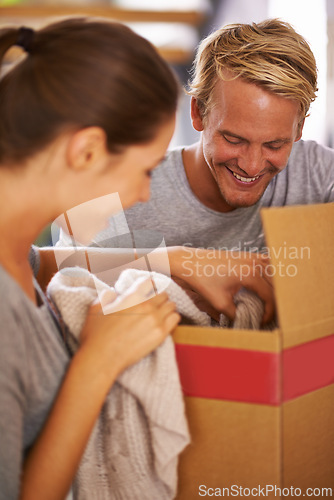 Image of Couple, moving and packing clothes in box and excited for new house and preparing for property. People, unboxing and happy to rent real estate, apartment and start of marriage in home together