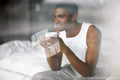 Image of Black man, thinking and morning with coffee in bed for breakfast, start or ambition at home. Young African or male person in wonder, thought or relax with mug, cappuccino or cup of tea in the bedroom