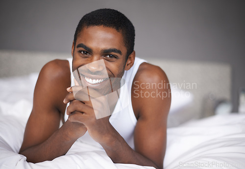 Image of Happy black man, portrait and relax with bed for morning, wakeup or holiday on break at home. Face of African male person with smile and lying in bedroom for weekend, peace or comfort at the house