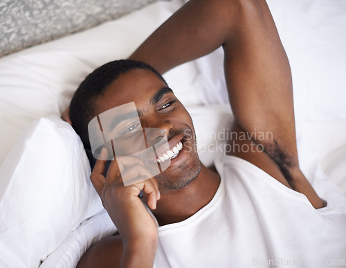 Image of Happy, black man and bed with phone for communication, conversation or networking in relax at home. Face of African male person with smile on mobile smartphone for discussion in bedroom at the house