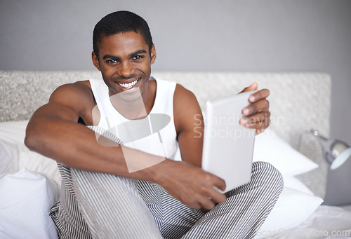 Image of Black man, portrait and bed with tablet for social media, communication or online entertainment at home. African male person with smile for technology, networking or browsing in bedroom at the house