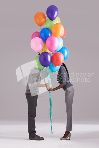 Image of Couple, party and celebration with balloons for event, birthday or romance on a gray studio background. Man and woman holding colorful blowups of helium for art, date or anniversary on mockup space