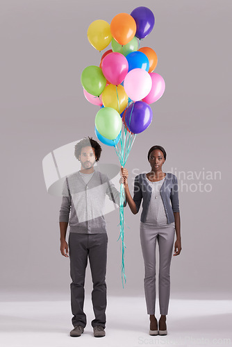 Image of Couple, portrait and party with balloons for celebration, event or romance on a gray studio background. Man and woman holding colorful blowups of helium for art, date or anniversary on mockup space