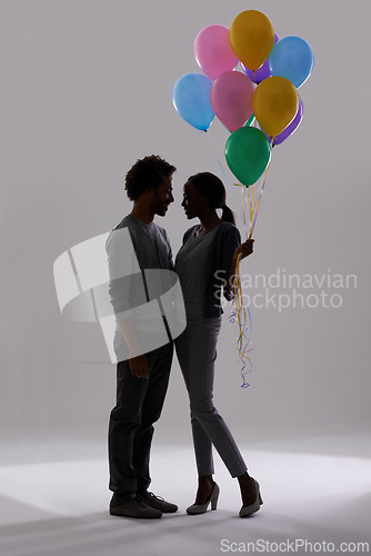 Image of Couple, silhouette and party with balloons for celebration, event or romance on a gray studio background. Man and woman holding colorful objects of helium for art, date or anniversary on mockup space