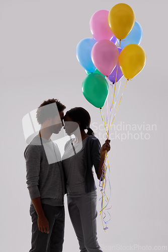 Image of Couple, silhouette and love with party balloons for celebration, event or romance on a gray studio background. Man and woman with colorful blowups of helium for date or anniversary on mockup space