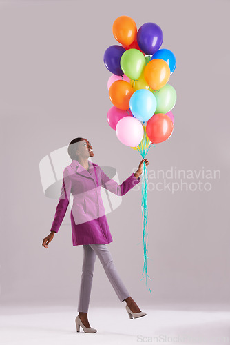 Image of Balloon, fashion and happy black woman in studio for birthday, celebration and present. Style, excited and isolated person smile with inflatables for party, gift and surprise on gray background