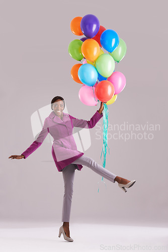 Image of Balloon, excited and portrait of black woman in studio for birthday, celebration and present. Happy, fashion and isolated person smile with inflatables for party, gift and surprise on gray background