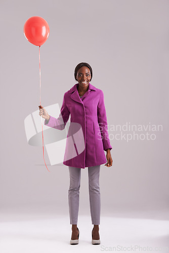 Image of Balloon, fashion and portrait of black woman in studio for birthday, celebration and present. Happy, excited and isolated person smile with inflatable for party, gift and surprise on gray background