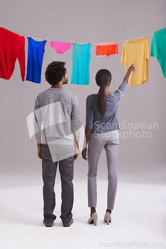 Image of Laundry, choice and clothing of couple with back view in studio for hygiene, housework, washing in white background. Domestic, black man and woman for household task, clean or fresh fabric on line