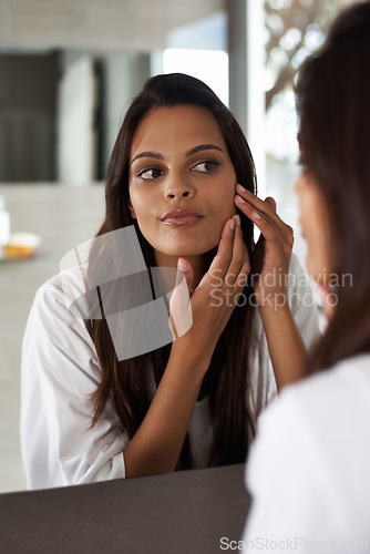 Image of Woman, check face in mirror and beauty with morning routine, acne and cosmetic care at home. Skincare, wellness and dermatology with skinlglow, reflection and grooming for hygiene in bathroom