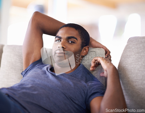 Image of Man, portrait and smile on sofa with relax in living room of home with comfort, confidence or weekend. Student, african person and happiness with face on couch in lounge for rest, day off or wellness