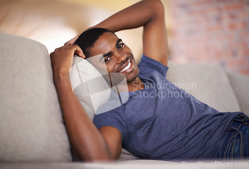 Image of Man, portrait and happiness on sofa with relax in living room of home with comfort, confidence or weekend. Student, african person and smile with face on couch in lounge for rest, day off or wellness