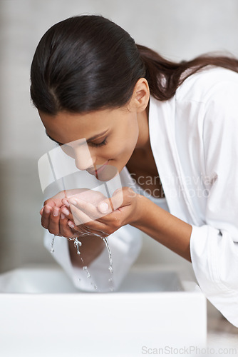 Image of Hands, water and woman wash face for beauty and skincare, wellness and splash in sink in bathroom. Facial, treatment and dermatology with hygiene, grooming and morning skin routine at apartment