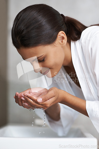 Image of Hands, water and woman washing face for beauty and skincare, wellness and splash in sink in bathroom. Facial, treatment and dermatology with hygiene, grooming and morning skin routine at home