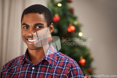 Image of Man, portrait and happy in home on christmas for celebration, holiday and festive spirit in living room. African person, face and smile on xmas with relax, confidence and vacation in lounge of house