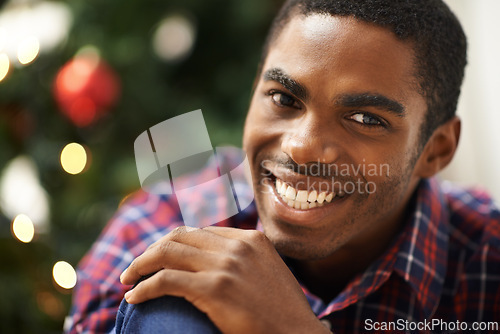 Image of Man, portrait and smile in home on christmas for celebration, holiday and festive spirit in living room. African person, face and happy on xmas with relax, confidence and vacation in lounge of house