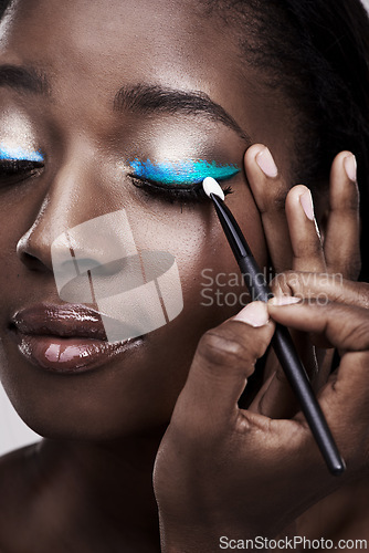 Image of Brush, makeup and face of black woman with cosmetics for wellness, beauty and model. Cosmetology, skincare and person with tools for makeover application, blue eyeshadow and products in studio