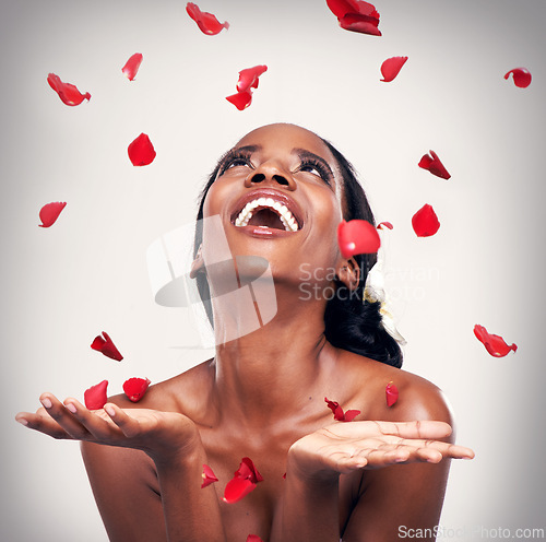 Image of Flower, throw and black woman in studio for makeup, beauty or wellness on grey background. Floral confetti, smile and African model with soft cosmetics, shine or organic, fun and transformation