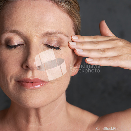 Image of Face, beauty and dermatology with mature woman in studio on gray background for aesthetic wellness. Skincare, facial and self care with natural skin person at spa for antiaging cosmetics or treatment