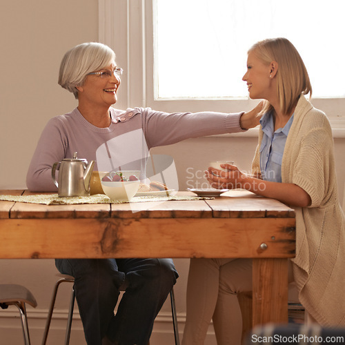 Image of House, senior and comfort to daughter, visit and elderly mom in dining table with food for breakfast, coffee and snacks with mother. Female person, smile and happiness with parent in family home