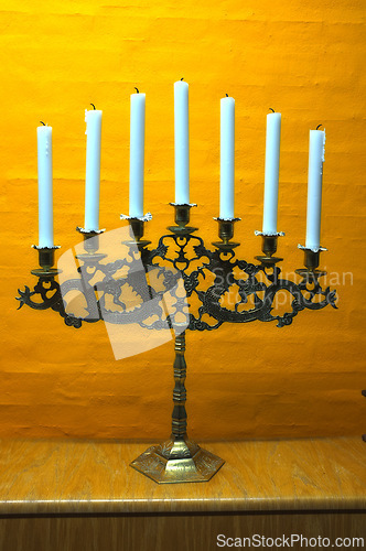Image of Candle, vintage and holder in church on table at interior of room or cathedral. Wax, brass and retro candlestick for decoration at temple, wood and copper metal with antique candelabra for lighting