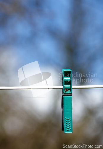 Image of Sky, line and plastic peg or pin for clothes, outdoor and closeup of clip on rope to hang. Metal, vibrant and tool to fasten laundry to dry, clean and washing on string, backyard and sunshine