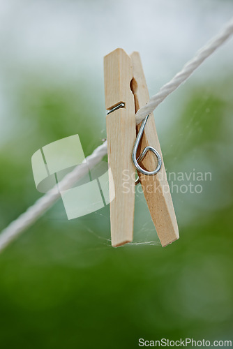 Image of Peg, rope and outdoor for clothes from laundry, clean and dry in nature with plastic clip of closeup. Washing, empty line and wooden tool to hang or pin cloth on wire, fasten and backyard AT house